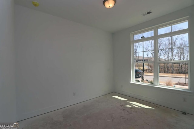 unfurnished room with visible vents, unfinished concrete flooring, and baseboards