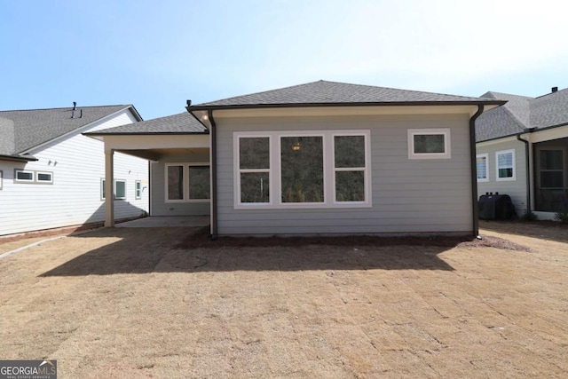 back of house with roof with shingles