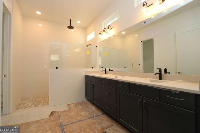 full bathroom featuring double vanity, walk in shower, and a sink