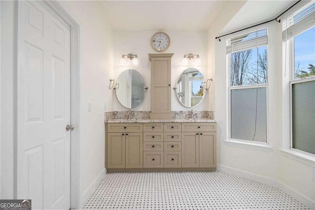 full bathroom with double vanity, baseboards, tile patterned floors, and a sink