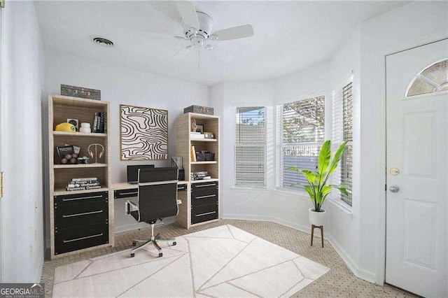 office area with visible vents, light speckled floor, baseboards, and a ceiling fan