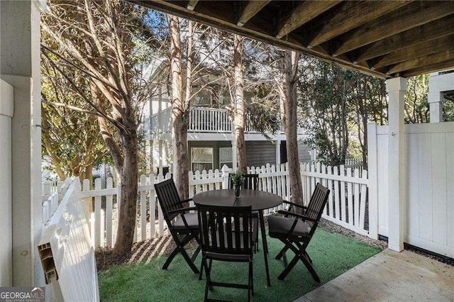 view of patio featuring outdoor dining area and fence