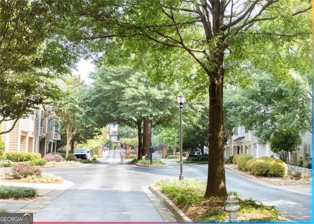 view of street featuring street lights and curbs