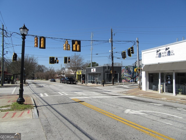 view of street with street lights, sidewalks, and traffic lights