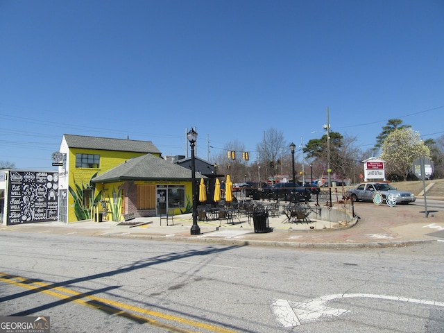 view of street with street lights, traffic lights, curbs, sidewalks, and traffic signs