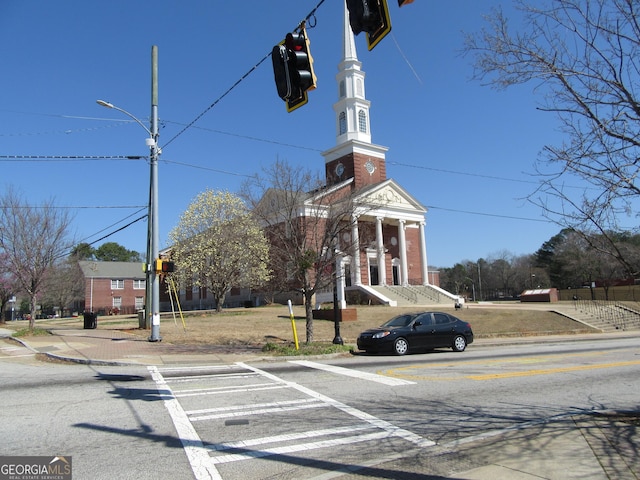 view of street featuring curbs, street lights, traffic lights, and sidewalks