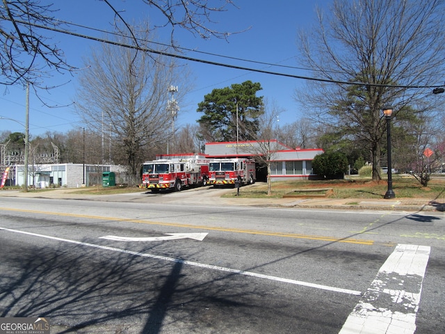 view of road featuring curbs, street lighting, and sidewalks