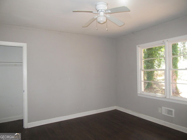 unfurnished bedroom featuring dark wood-type flooring, baseboards, visible vents, and a closet