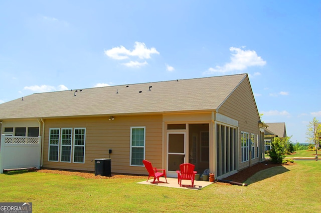 back of property featuring a yard, a patio, and a sunroom