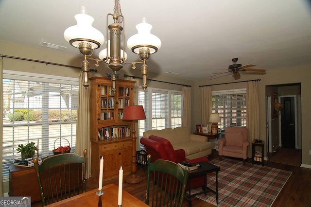 interior space featuring visible vents, ceiling fan with notable chandelier, and wood finished floors