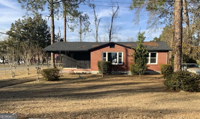 view of front of house featuring brick siding and a front yard