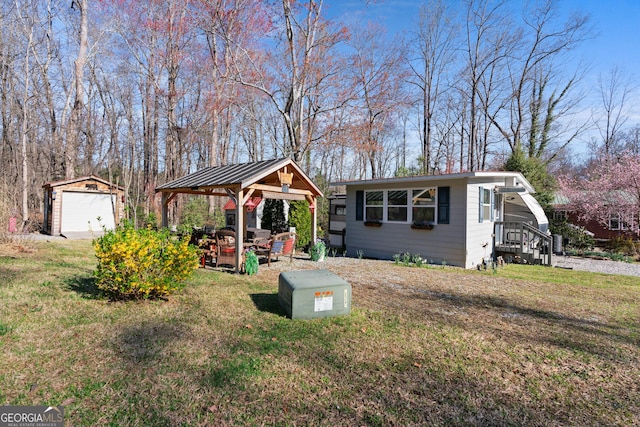 exterior space with an outbuilding, a front lawn, a gazebo, and a detached garage