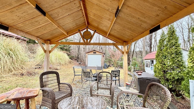 view of patio / terrace with outdoor dining space, an outdoor structure, a gazebo, a storage shed, and an outdoor hangout area