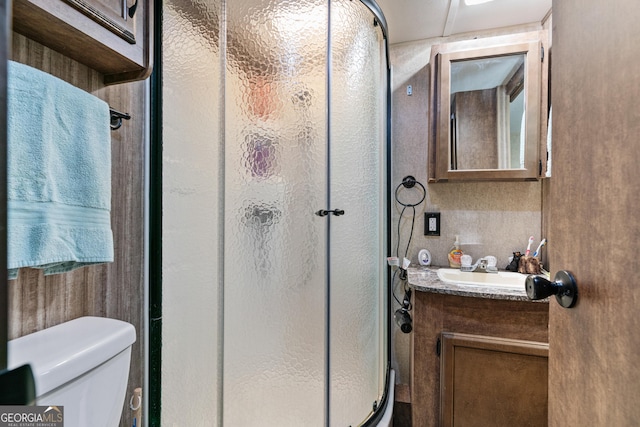 full bath featuring a stall shower, toilet, and vanity
