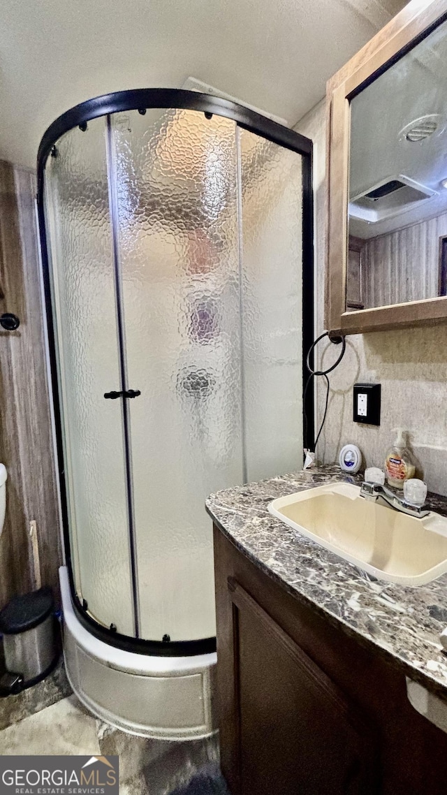 full bathroom featuring vanity and a shower stall