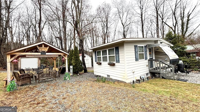 view of front of property featuring a front yard, a gazebo, dirt driveway, crawl space, and outdoor lounge area