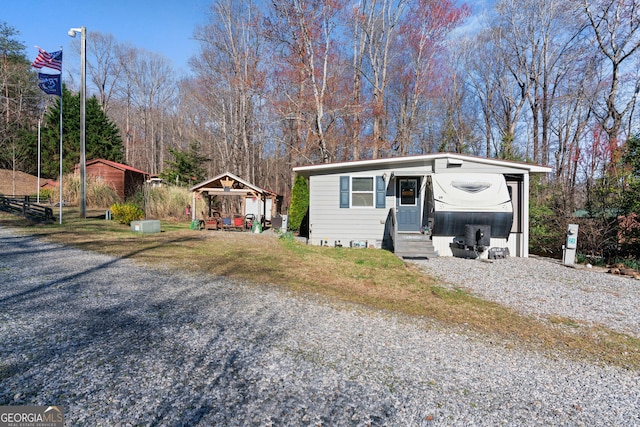 exterior space with driveway, a detached carport, and entry steps