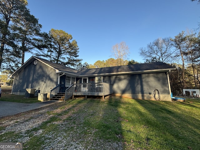 view of front of house featuring a deck, a front yard, and central AC unit