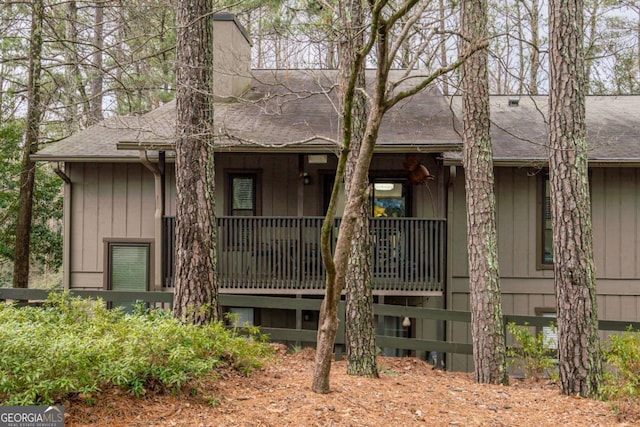 view of front facade with board and batten siding and a shingled roof