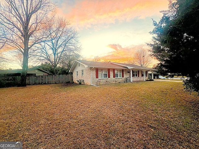 view of front of home with a front lawn, fence, and brick siding