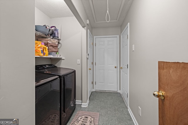 laundry area with baseboards, attic access, laundry area, and washer and clothes dryer