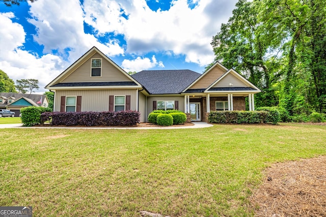 craftsman house featuring a shingled roof and a front lawn