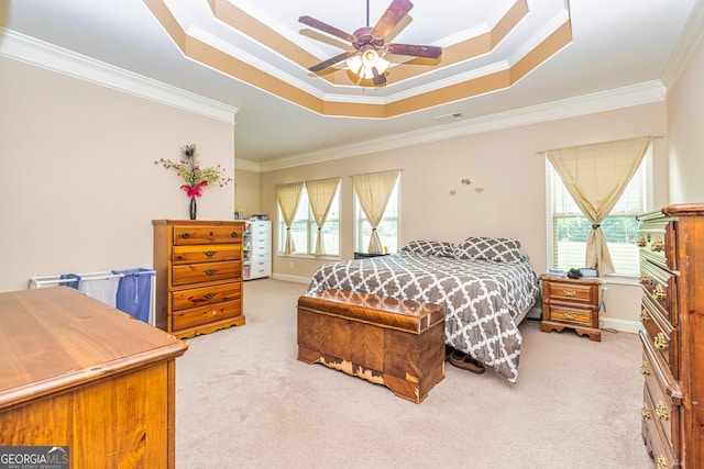 bedroom featuring crown molding, a tray ceiling, light colored carpet, and visible vents