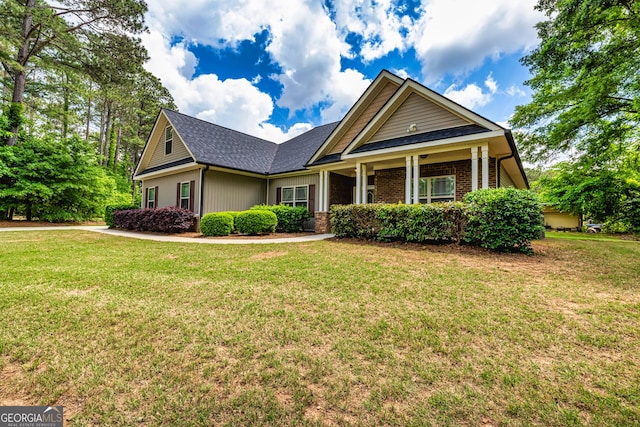 craftsman-style home featuring brick siding and a front yard