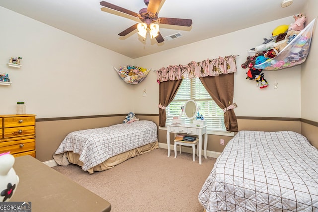 carpeted bedroom featuring baseboards, a ceiling fan, and visible vents