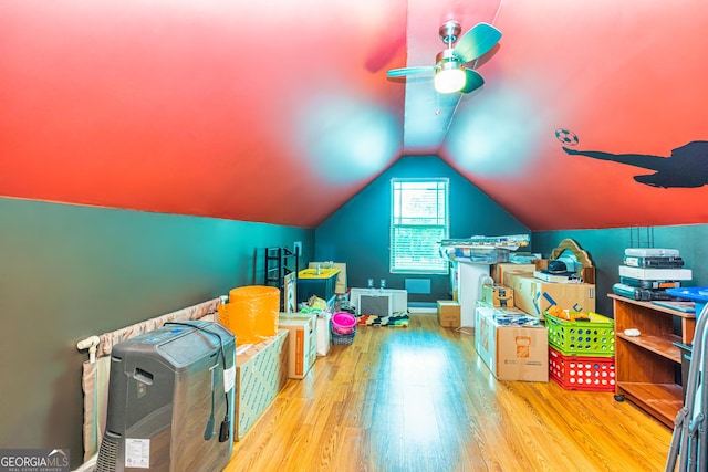 recreation room with ceiling fan, wood finished floors, and vaulted ceiling
