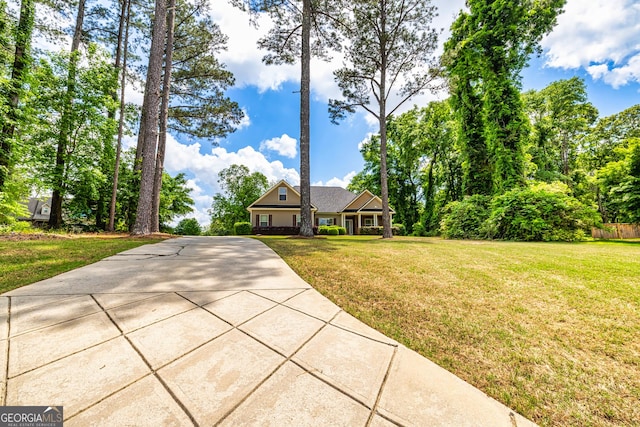 view of front of property featuring concrete driveway and a front yard