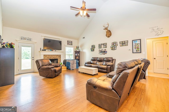 living area featuring plenty of natural light, a ceiling fan, light wood-style flooring, and high vaulted ceiling