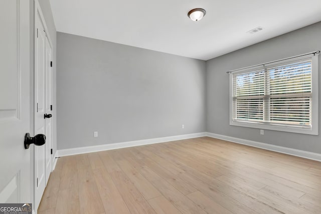 spare room with visible vents, baseboards, and light wood finished floors