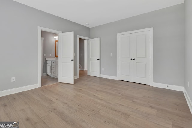 unfurnished bedroom featuring a closet, baseboards, and light wood-style floors