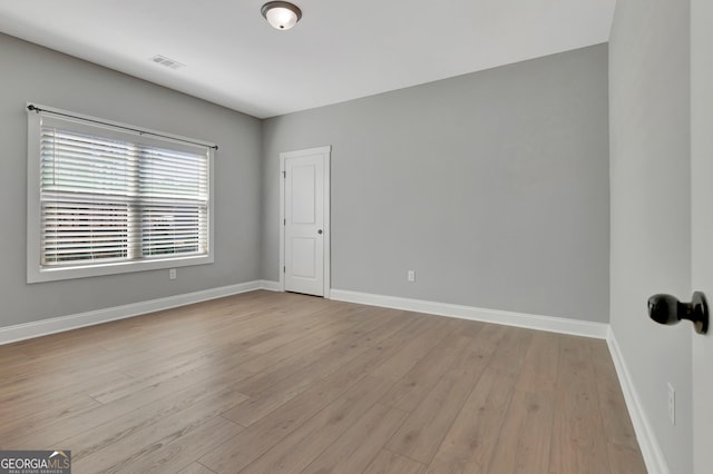 unfurnished room featuring visible vents, baseboards, and light wood finished floors