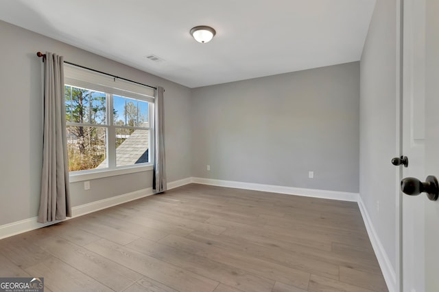 unfurnished room featuring visible vents, baseboards, and light wood-style floors