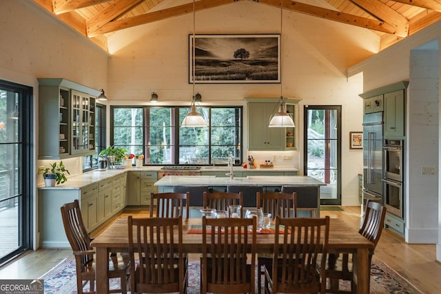 dining space featuring wood ceiling, lofted ceiling with beams, and light wood-style floors