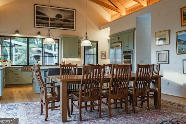 dining room with light wood finished floors, beamed ceiling, wooden ceiling, and high vaulted ceiling