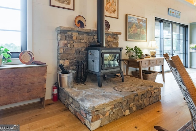 room details with wood finished floors, a wood stove, and a fire extinguisher