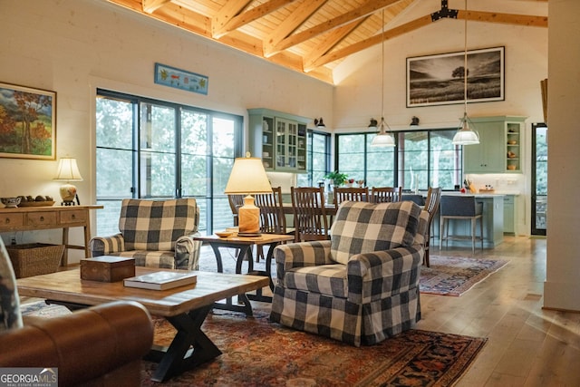 living room with beam ceiling, high vaulted ceiling, wood ceiling, and wood-type flooring