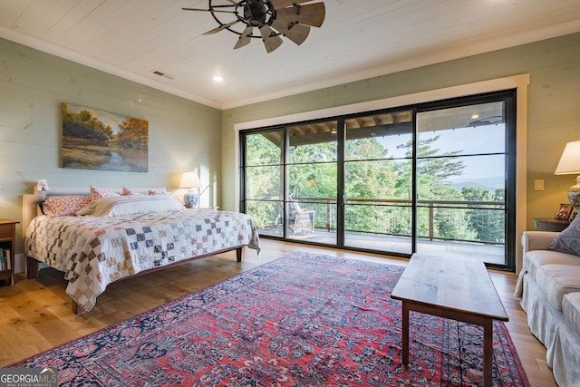 bedroom with wooden walls, wood finished floors, visible vents, wood ceiling, and access to outside