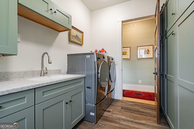 clothes washing area featuring baseboards, cabinet space, separate washer and dryer, dark wood-style flooring, and a sink