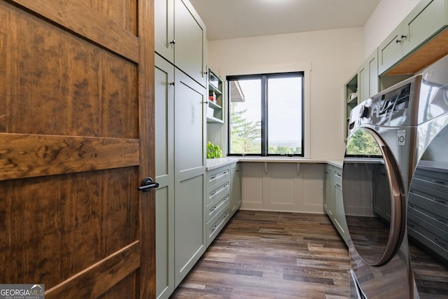 laundry area with dark wood finished floors, cabinet space, and separate washer and dryer