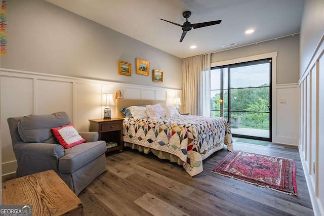 bedroom with access to exterior, a decorative wall, wood finished floors, and visible vents