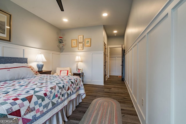 bedroom featuring recessed lighting, a decorative wall, wainscoting, and wood finished floors