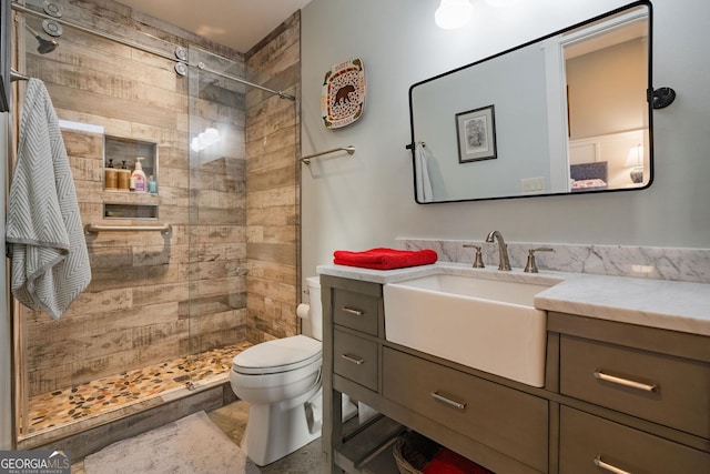 full bathroom featuring a shower stall, toilet, and vanity