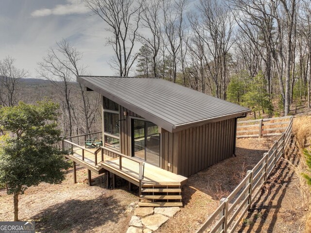 view of outdoor structure featuring a forest view and fence