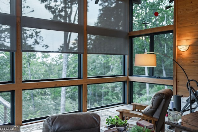 living room featuring wooden walls, a high ceiling, and a wealth of natural light