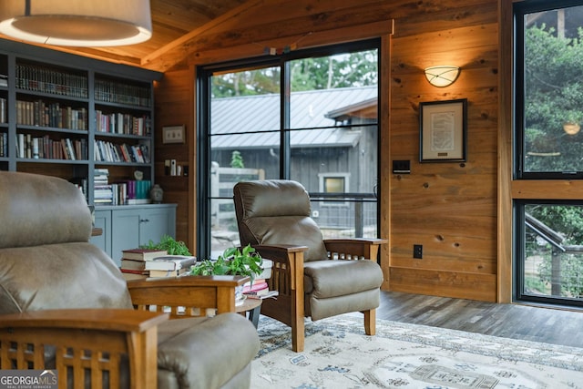 living area featuring vaulted ceiling, wood finished floors, and wood walls