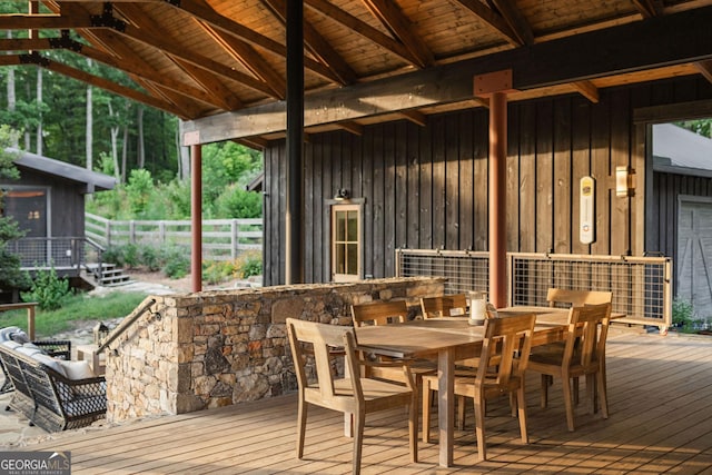 wooden terrace with outdoor dining space and fence